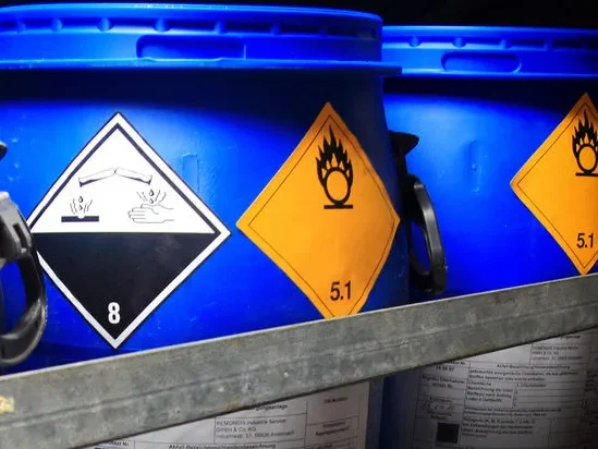 Zwei rote Feuerlöscher mit Griff und Schlauch, an einer Wand montiert.